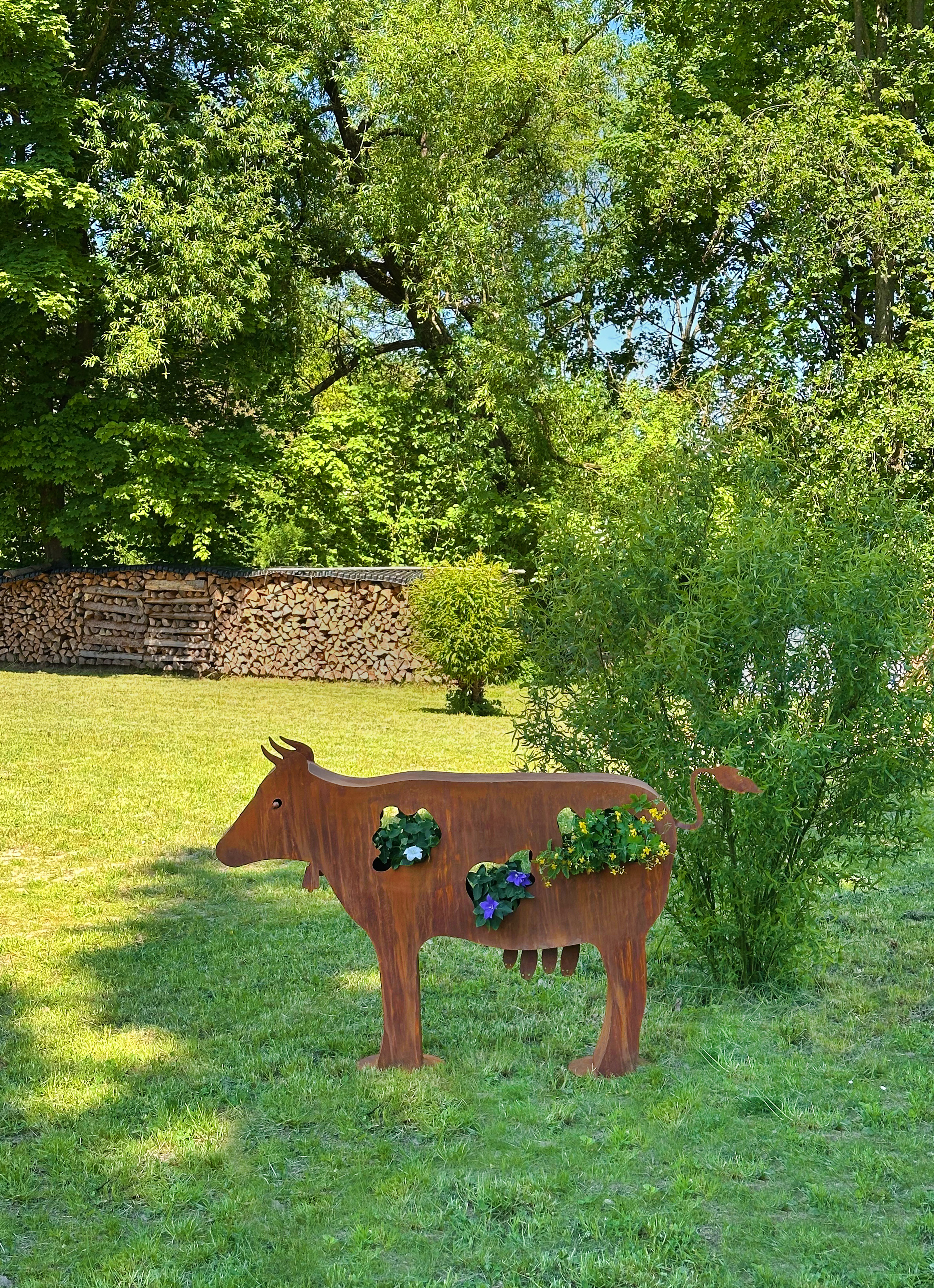 Kuh Berta aus Edelrost als große Gartendeko mit Pflanzfächern im Außenbereich