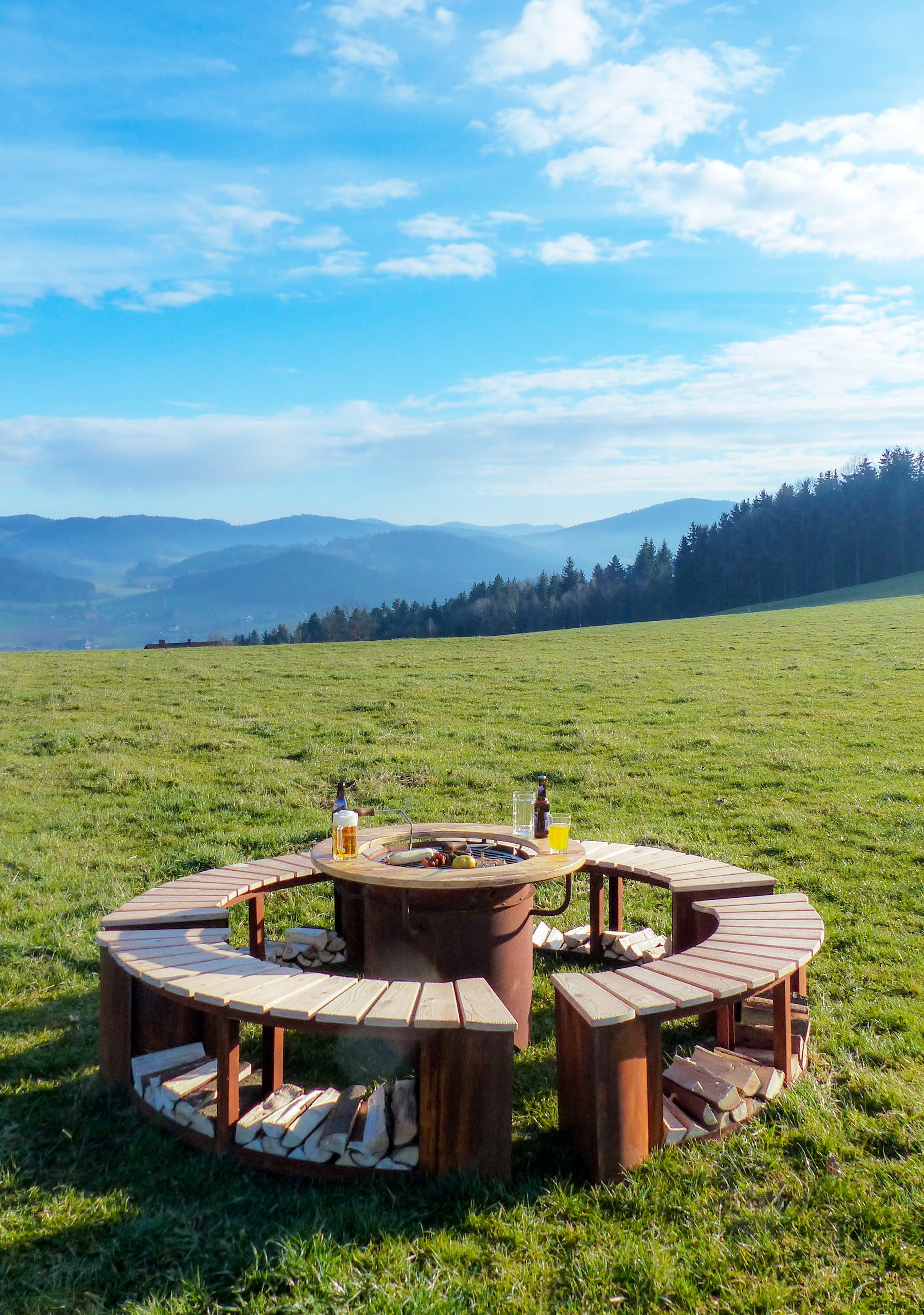 Grill-Feuerstelle Freiburg aus Edelrost mit runder Sitz- und Ablagefläche im Garten