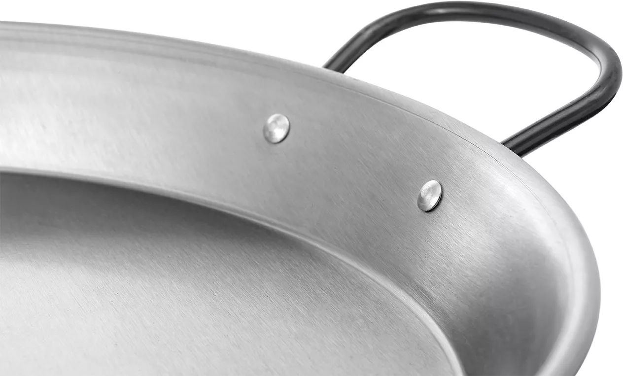 Detail einer Vaello-Induktionspaellapfanne aus poliertem Stahl mit glattem Boden und vernietetem Griff